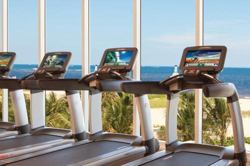 a row of treadmill machines with the ocean in the background at Fort Lauderdale Marriott Pompano Beach Resort in Pompano Beach