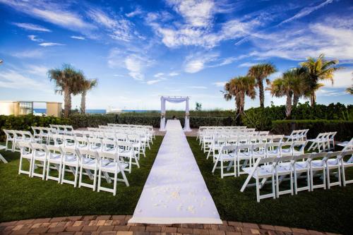 a wedding ceremony with white chairs and a white aisle at Fort Lauderdale Marriott Pompano Beach Resort in Pompano Beach