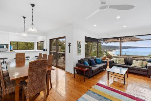 a dining room and living room with a table and chairs at The George in Lorne