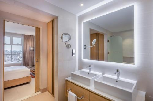 a bathroom with two sinks and a mirror at Residence Inn by Marriott Dammam in Dammam