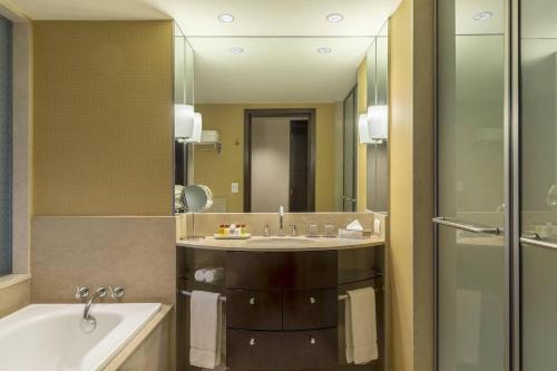 a bathroom with a sink and a tub and a mirror at Sheraton Mendoza Hotel in Mendoza