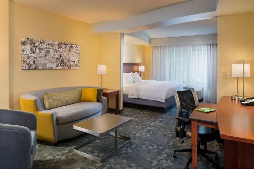 a hotel room with a bed and a living room at Courtyard by Marriott Hanover Lebanon in Lebanon