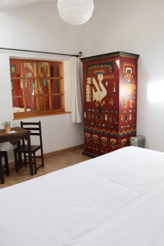 a bedroom with a bed and a table and a cabinet at Hotel Villa Urubamba in Urubamba