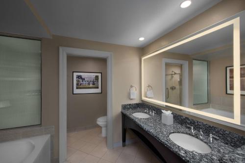 Marriott's OceanWatch Villas at Grande Dunes في ميرتل بيتش: حمام به مغسلتين وحوض استحمام ومرحاض