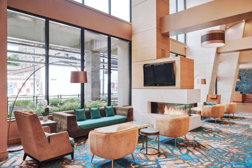 a lobby with a fireplace and chairs and a tv at Residence Inn by Marriott Vancouver Downtown in Vancouver