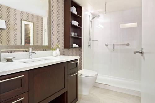 a bathroom with a shower and a sink and a toilet at Residence Inn by Marriott Vancouver Downtown in Vancouver