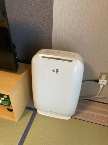 a toilet sitting on the floor next to a desk at Route Inn Grantia Fukuoka Miyawaka - Wakita Onsen in Miyawaka