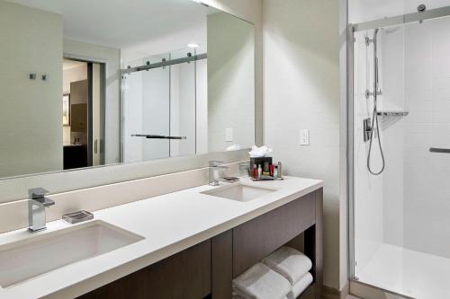 a bathroom with two sinks and a large mirror at Marriott Hartford/Windsor Airport in Windsor
