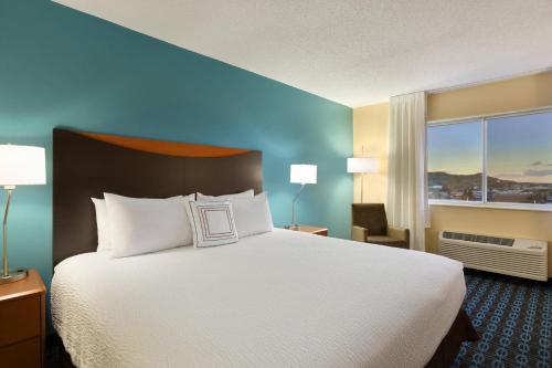 um quarto de hotel com uma cama e uma grande janela em Fairfield Inn Colorado Springs Air Force Academy em Colorado Springs