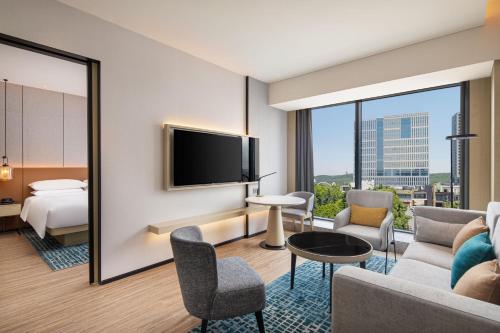 a hotel room with a bed and a tv at Courtyard by Marriott Jiangyin in Jiangyin