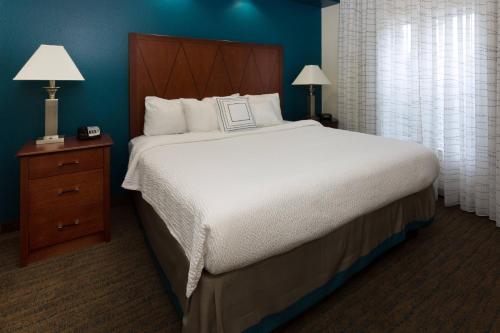 a bedroom with a large bed with a wooden headboard at Residence Inn by Marriott Baton Rouge near LSU in Baton Rouge