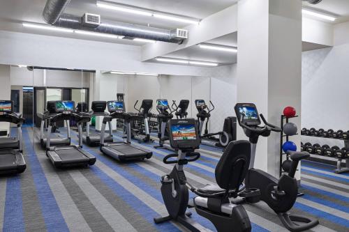 a gym with rows of treadmills and elliptical machines at Aloft Houston Downtown in Houston