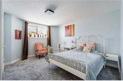 a bedroom with a bed and a chair and a window at Banff Garden Suite&2mins Bus station Close LRT& Free Parking in Calgary