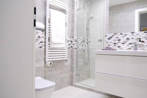 een badkamer met een douche, een toilet en een wastafel bij Urban Jungle Garden & Patio - Luksusowy apartament w Gdyni in Gdynia