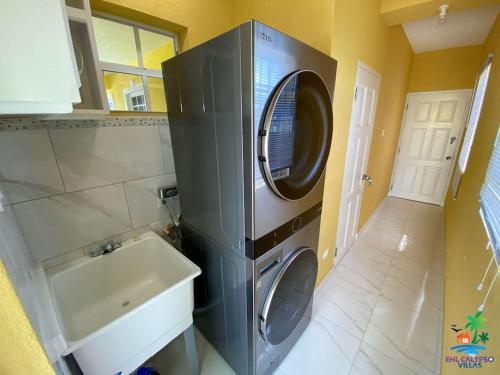 una lavatrice in una cucina accanto a un lavandino di EHL Grand 8Bed 9bath, Fully Furnished Air Conditioned Villa 5min to Beach a Saint Philip
