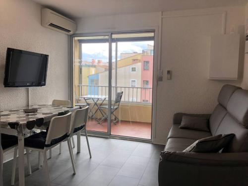 - un salon avec une table, un canapé et une télévision dans l'établissement Appartement moderne, climatisé, quartier calme, proche commodités, avec parking privatif - FR-1-723-17, au Cap d'Agde