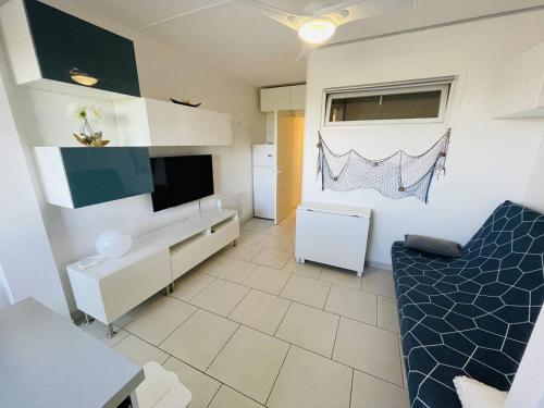 - un salon avec un canapé et une télévision dans l'établissement Superbe studio refait à neuf, parking privatif près des falaises - FR-1-723-29, au Cap d'Agde