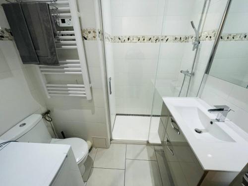une salle de bain blanche avec des toilettes et un lavabo dans l'établissement Superbe studio refait à neuf, parking privatif près des falaises - FR-1-723-29, au Cap d'Agde