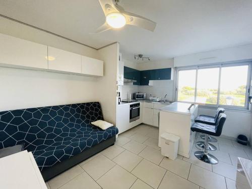 un salon avec un canapé et une cuisine dans l'établissement Superbe studio refait à neuf, parking privatif près des falaises - FR-1-723-29, au Cap d'Agde