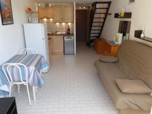 Il dispose d'une cuisine et d'un salon avec un canapé et une table. dans l'établissement Appartement climatisé avec terrasse, piscine et proche plage à Cap d'Agde - FR-1-723-15, au Cap d'Agde