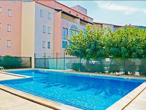 une piscine devant un immeuble dans l'établissement 2 pièces, plage Richelieu, piscine, parking - FR-1-723-34, au Cap d'Agde