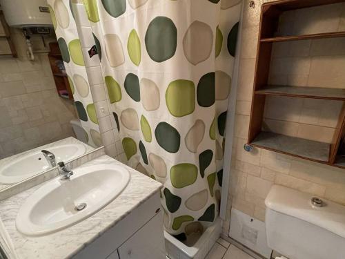ein Bad mit einem Waschbecken und einem Duschvorhang in der Unterkunft Studio Cap d'Agde, 1 pièce, 3 personnes - FR-1-723-41 in Cap d'Agde