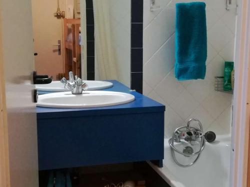 La salle de bains est pourvue d'un lavabo blanc et d'un comptoir bleu. dans l'établissement Studio cabine avec piscine, parking, climatisation, proche plage - FR-1-723-30, au Cap d'Agde