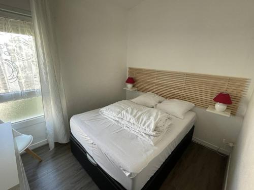 - une chambre avec un lit avec des draps blancs et 2 lampes dans l'établissement Appartement T3 Duplex avec Terrasse, Parking et Wi-Fi au Port - FR-1-723-38, au Cap d'Agde