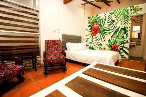 a room with a bedroom with a bed and a chair at La Casona de Sara in Honda