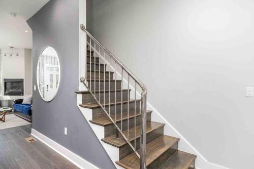 a staircase in a living room with a mirror at Family-Friendly 4BR Retreat Sleeps 12, Private Yard, Garage, Close to Stadiums, Casino & Downtown in Pittsburgh