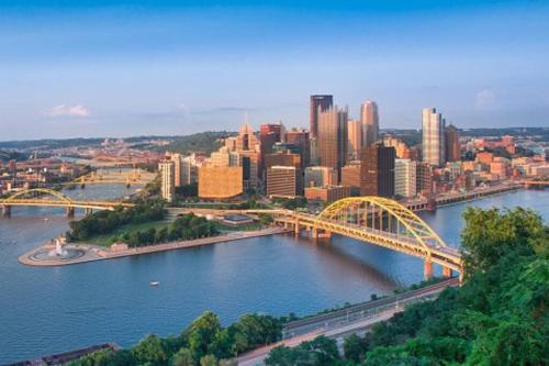 a view of a city with a bridge over a river at Family-Friendly 4BR Retreat Sleeps 12, Private Yard, Garage, Close to Stadiums, Casino & Downtown in Pittsburgh