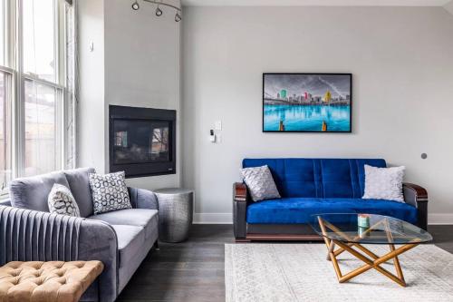 a living room with a blue couch and a table at 4 Bedroom 3 Bath Sleeps 10 Pet Friendly Private Backyard, 2 Car Garage, City Views, Close to all Stadiums and Casino in Pittsburgh