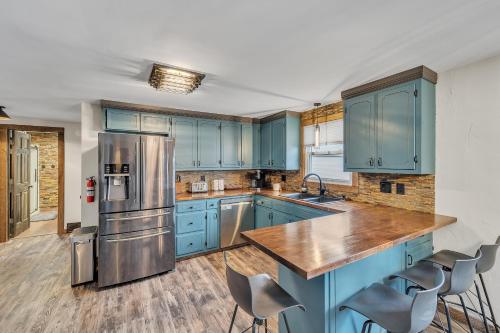 cocina con armarios azules y nevera de acero inoxidable en Titletown Hideaway- Spacious BoHo home en Green Bay