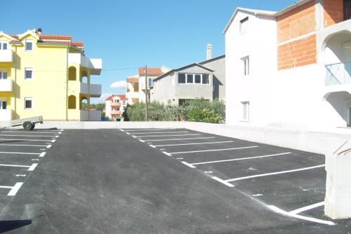 un estacionamiento vacío con edificios en el fondo en Apartments Tomić, en Vodice