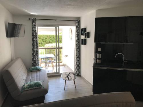 d'un salon avec un canapé et une table ainsi que d'un balcon. dans l'établissement Studio moderne avec loggia, proche port et plage, Cap d'Agde - FR-1-723-63, au Cap d'Agde