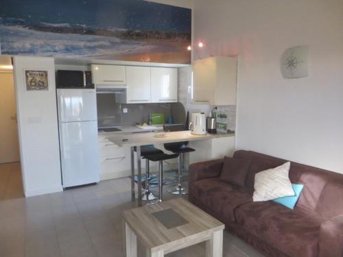 un salon avec un canapé et une cuisine dans l'établissement Bel appart neuf proche plage Richelieu, 6 pers, parking inclus - FR-1-723-79, au Cap d'Agde