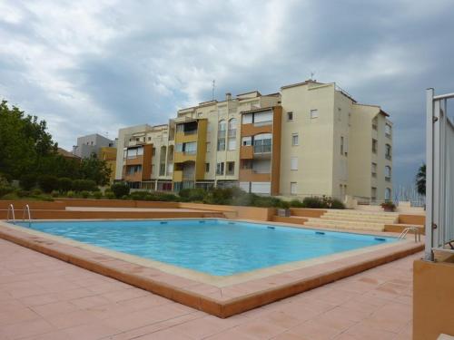 une grande piscine devant certains bâtiments dans l'établissement Appartement Cosy pour 4 avec Terrasse, Piscine et Parking au Centre-Port – Proche Plage ! - FR-1-723-69, au Cap d'Agde