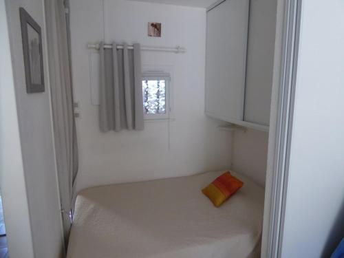 Habitación blanca pequeña con ventana y cama en Appartement Cap d'Agde, 2 pièces, 4 personnes - FR-1-723-83, en Cap d'Agde