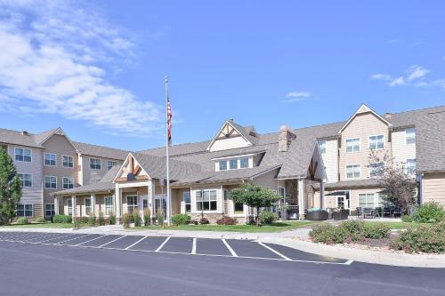 a building with an american flag in a parking lot at Residence Inn by Marriott Loveland Fort Collins in Loveland