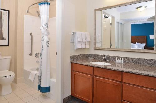 a bathroom with a sink and a toilet and a mirror at Residence Inn by Marriott Loveland Fort Collins in Loveland