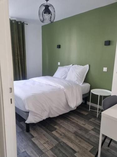 - une chambre avec un lit blanc et une table dans l'établissement Charmant appartement proche de la défense, à Rueil-Malmaison