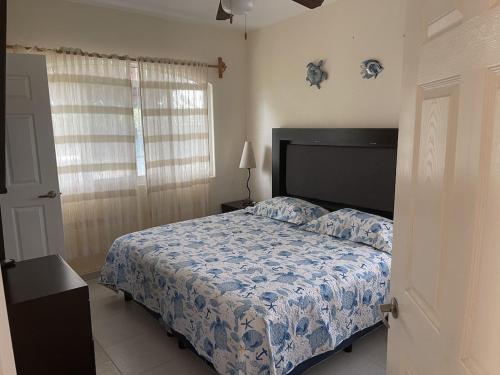 a bedroom with a bed with a blue comforter at Casa Margarita 3BR Private Home with Balcony in Pérula