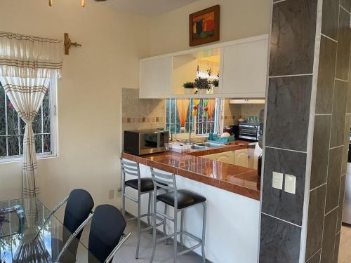 a kitchen with a counter and some stools in it at Casa Margarita 3BR Private Home with Balcony in Pérula