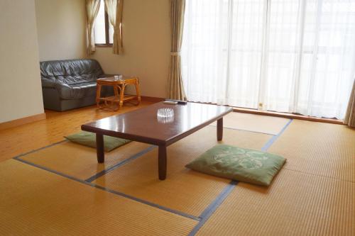 a living room with a coffee table and a couch at タートルハウス in Shimoda
