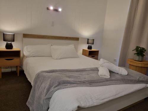 a bedroom with a large white bed with two lamps at Warm Cosy Paynesville Get-Away in Paynesville
