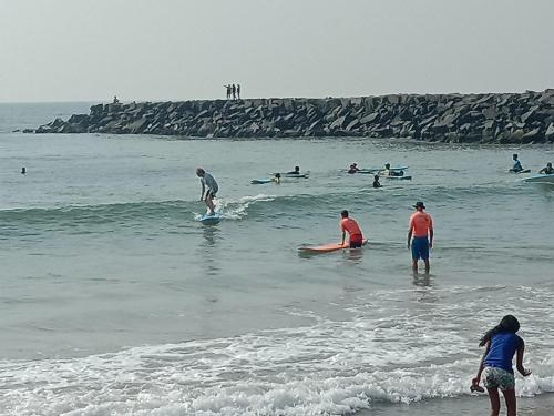 a group of people in the water at the beach at Thendralhomestay in Puducherry