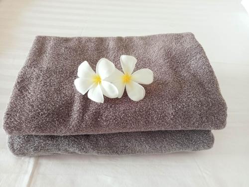 ein Handtuch mit zwei weißen Blumen darauf in der Unterkunft The Ocean Phangan Homestay in Haad Rin