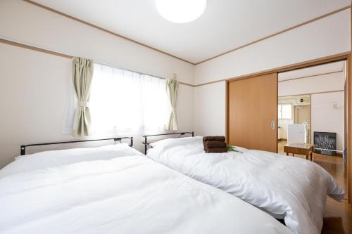 2 camas en un dormitorio con espejo en コーポウメザキ, en Ogikubo