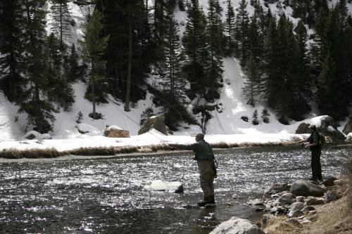 two people standing in a river flying a kite at Montana Spirit Guest Lodge in Cliff Lake