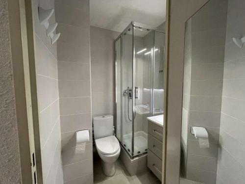 une salle de bain blanche avec douche et toilettes dans l'établissement Appartement 2 pièces avec loggia et piscine à 100m de la plage - Le Grau-du-Roi - FR-1-250-250, au Grau-du-Roi